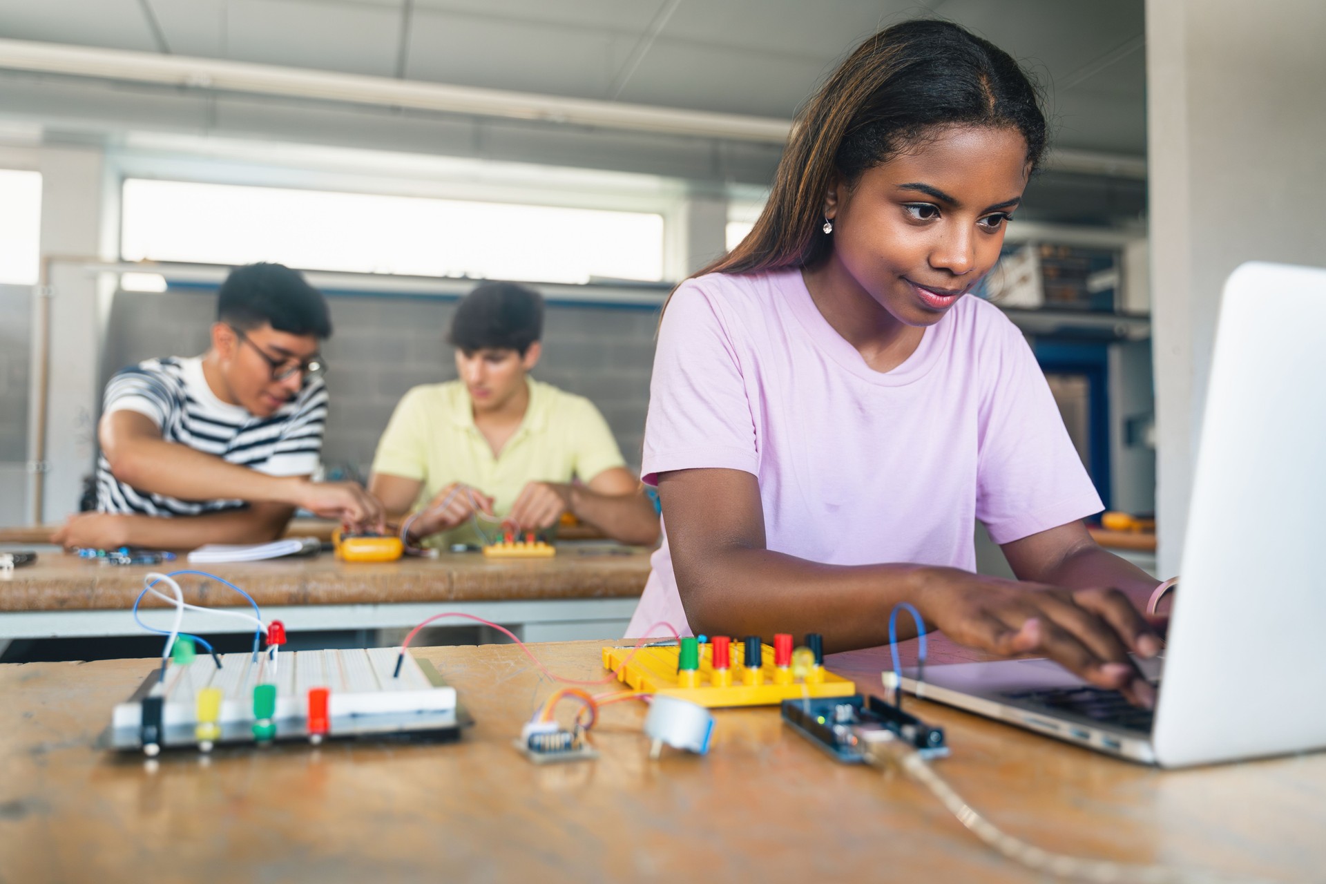 Female Student programming electronics circuit board in the engineering course - Technology girl at school