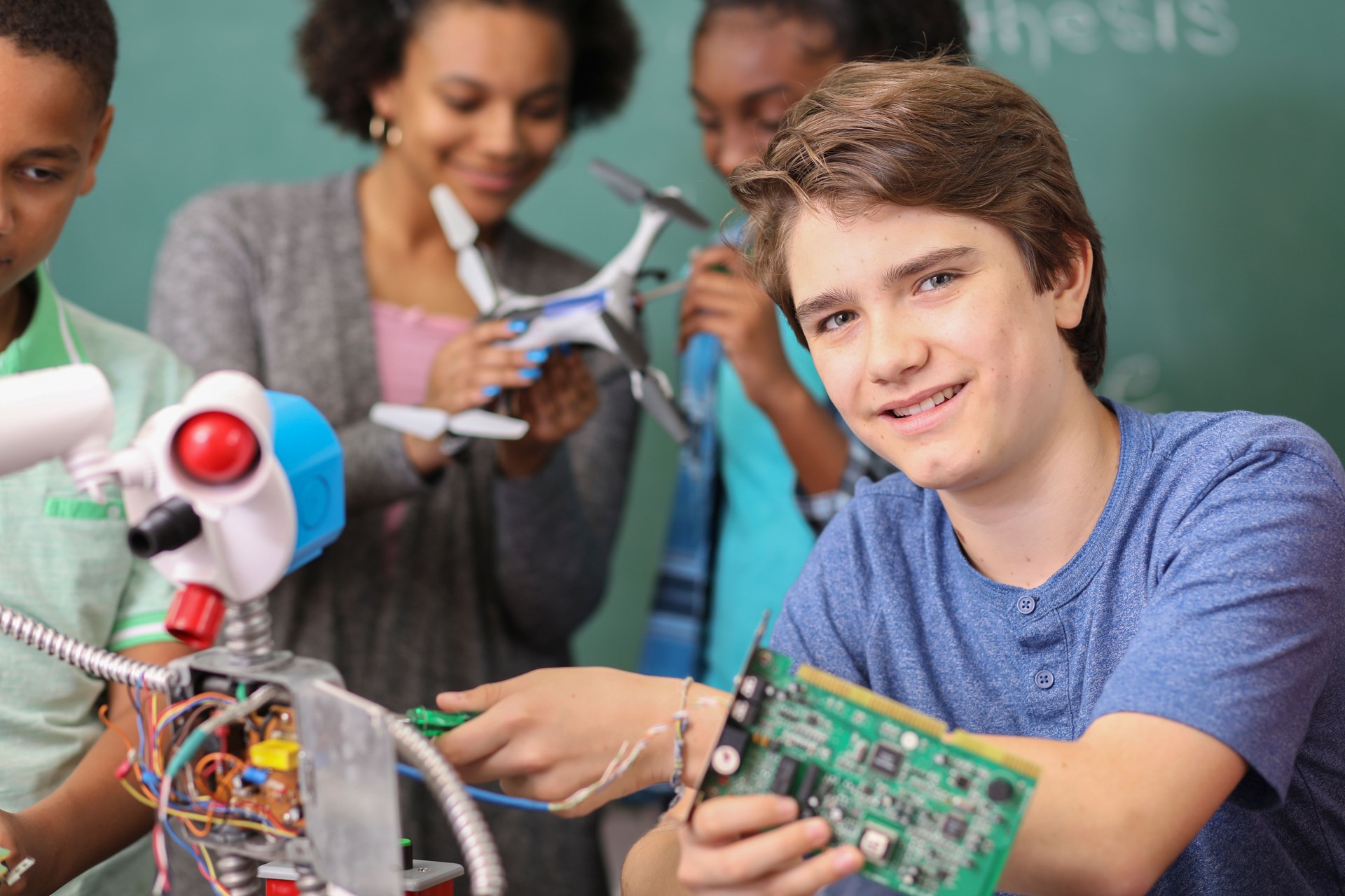 Junior high age school students build robot in technology, engineering class.
