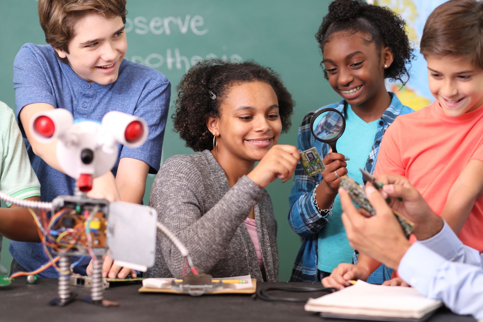 Junior high age school students build robot in technology, engineering class.