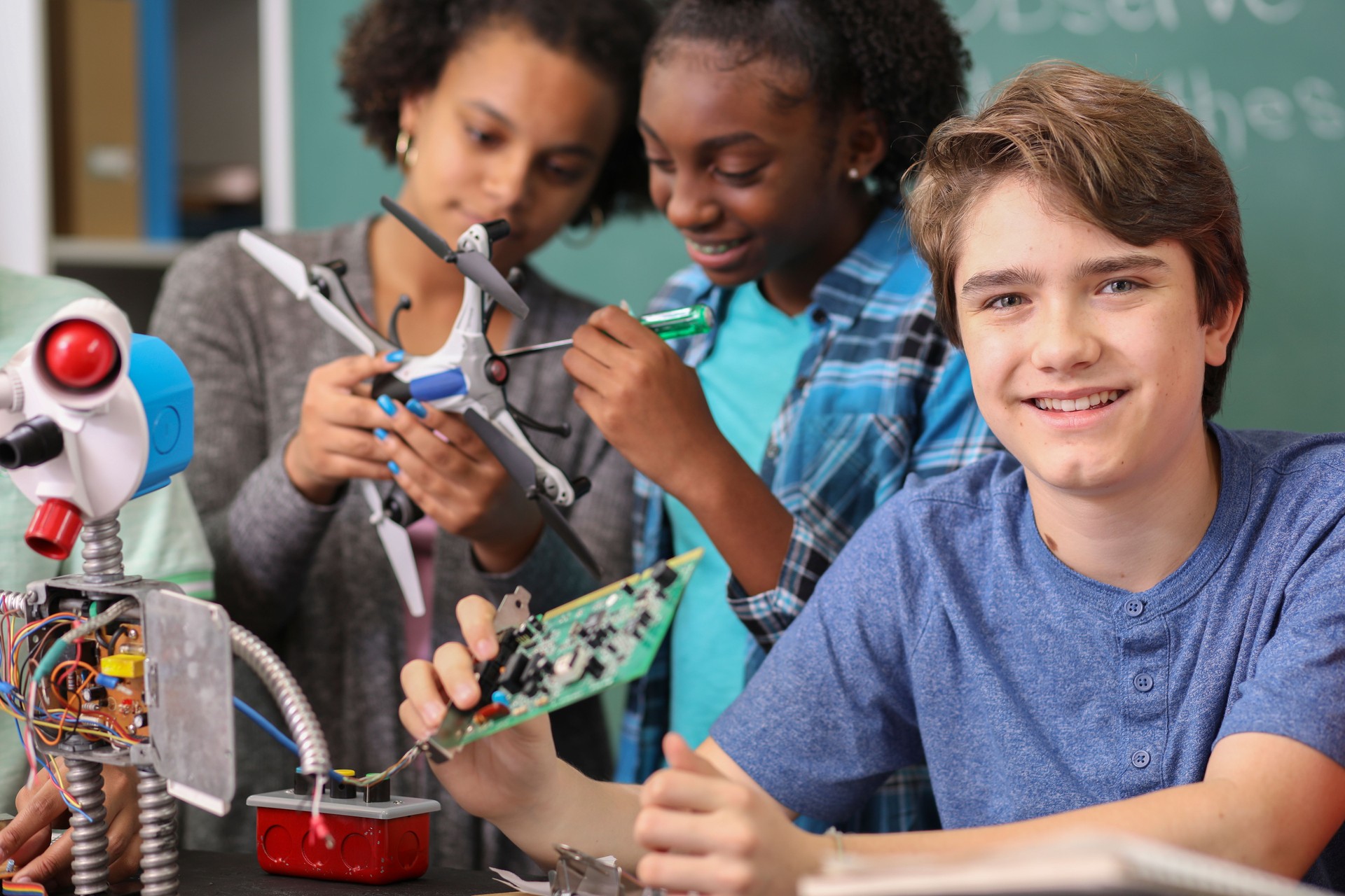 Junior high age school students build robot in technology, engineering class.